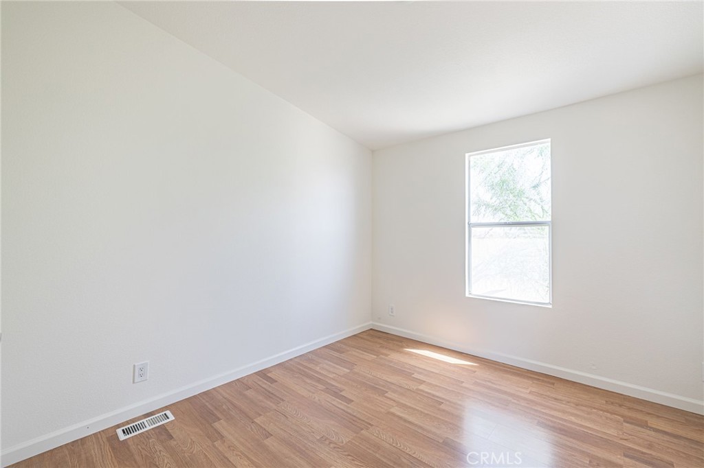 26321 Olanche Street Mojave, CA 93501 - Photo 29 of 39 an empty room with wooden floor and windows