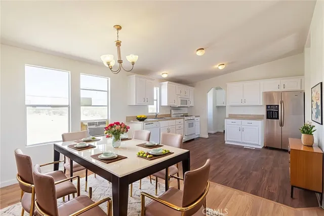 a large kitchen with kitchen island a white cabinets and wooden floor