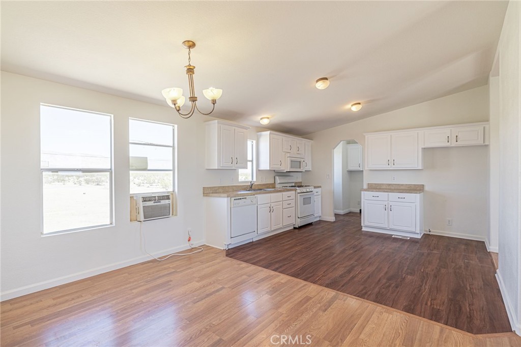 26321 Olanche Street Mojave, CA 93501 - Photo 10 of 39 a large kitchen with kitchen island a white cabinets and wooden floor