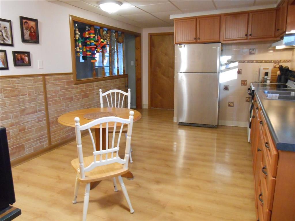 175 Elm Road Plum, PA 15239 - Photo 5 of 21 Another view of the large kitchen/dining room. Electric stove and stainless steel refrigerator will stay.Spindled opening allows for "peeking" into the living room from the kitchen! The natural wood door seen in this photo (near refrigerator) leads to large full bath.