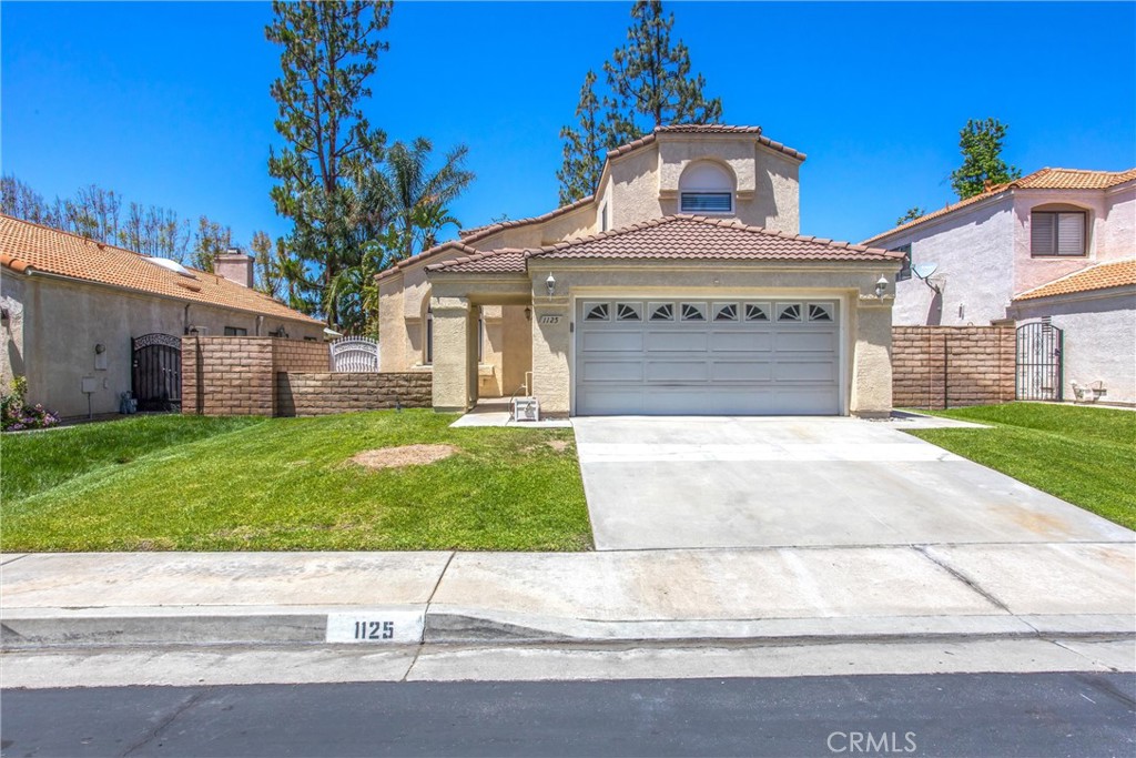 1125 Vía Nice Redlands, CA 92374 - Photo 2 of 50 a front view of a house with a garden and yard