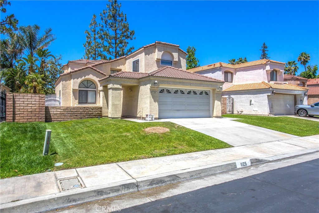 1125 Vía Nice Redlands, CA 92374 - Photo 3 of 50 a front view of a house with a garden and yard