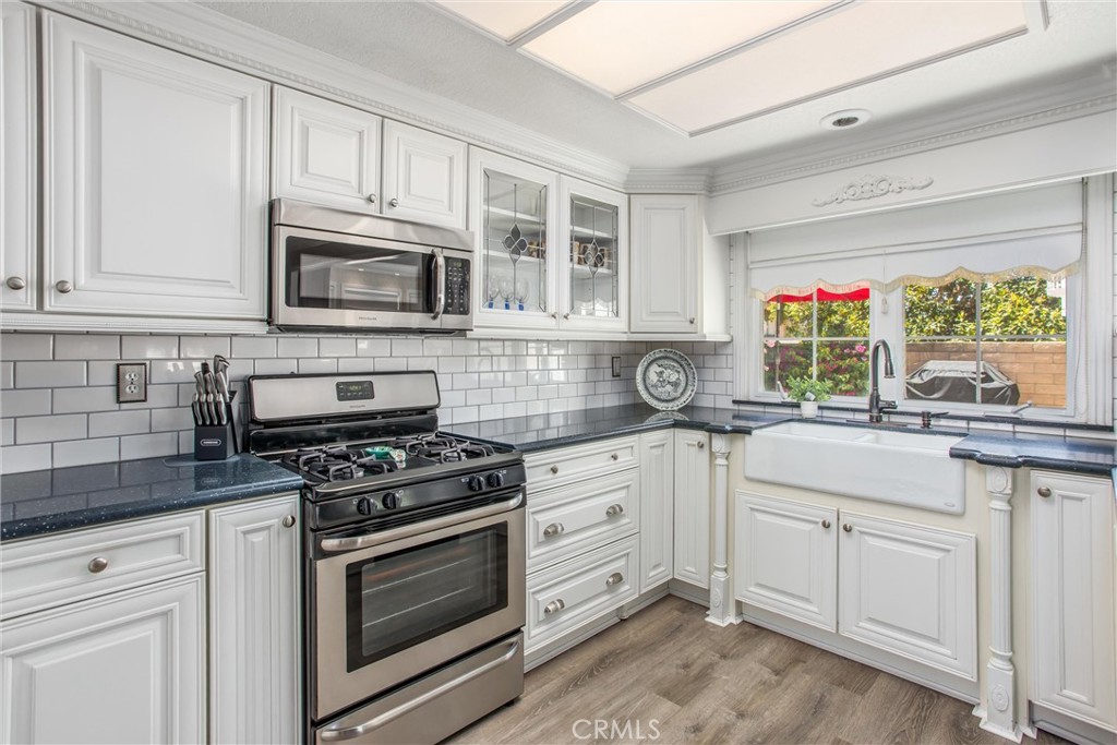1125 Vía Nice Redlands, CA 92374 - Photo 10 of 50 a kitchen with cabinets appliances a sink and a window