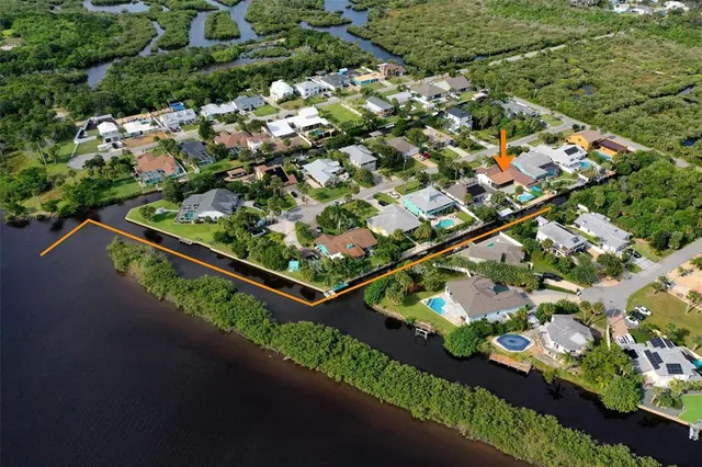 a view of a dining room and livingroom with furniture wooden floor a chandelier