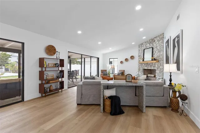 a living room with furniture floor to ceiling window and wooden floor
