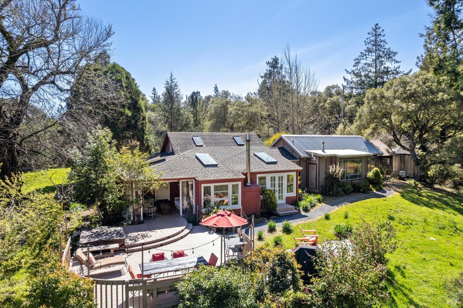 a view of a house with a big yard plants and large trees