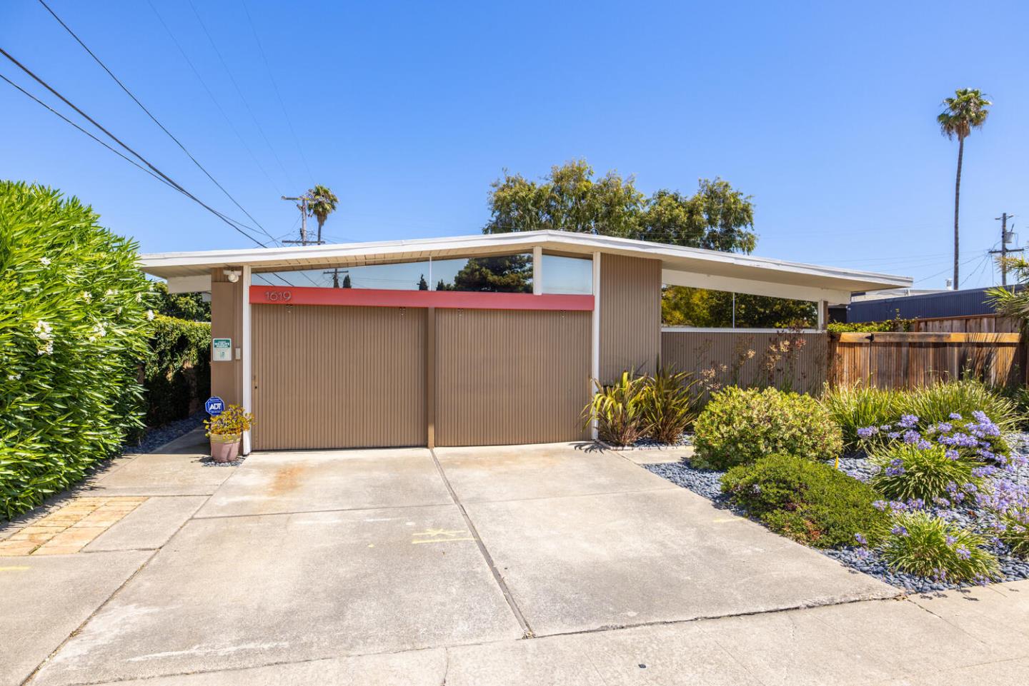 a front view of a house with a yard and potted plants