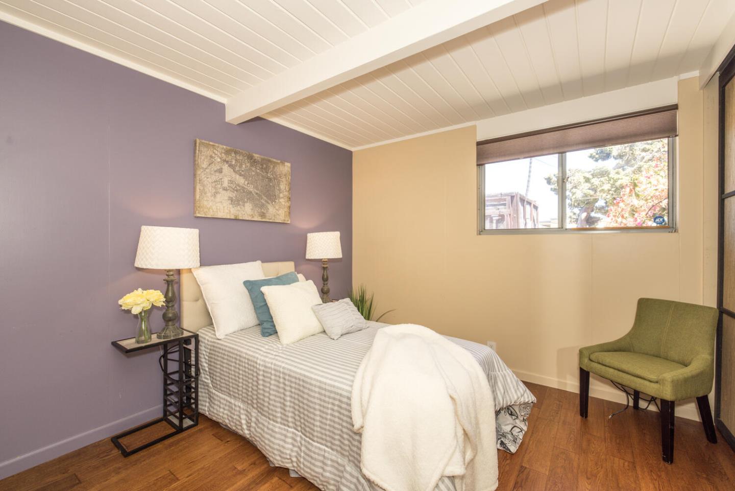 1619 Celeste Drive San Mateo, CA 94402 - Photo 29 of 44 a bedroom with a bed a painting on the wall and a wooden floor