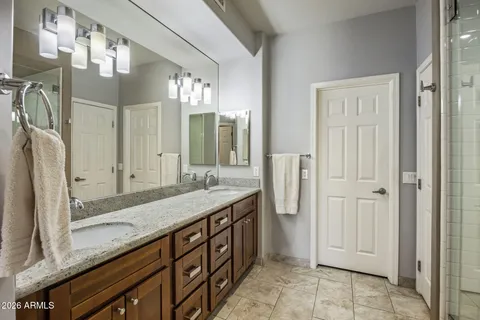 a spacious bathroom with a granite countertop sink mirror and a shower