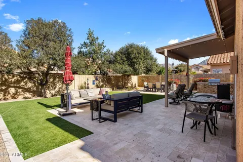 a view of a patio with table and chairs under an umbrella