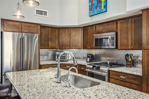 a kitchen with granite countertop a refrigerator stove and sink
