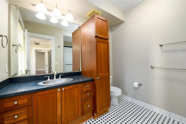a bathroom with a sink a toilet a mirror and shower