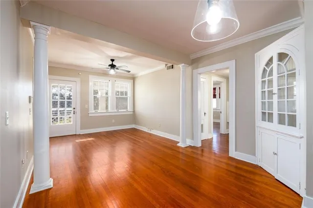 a view of an empty room with a window and wooden floor