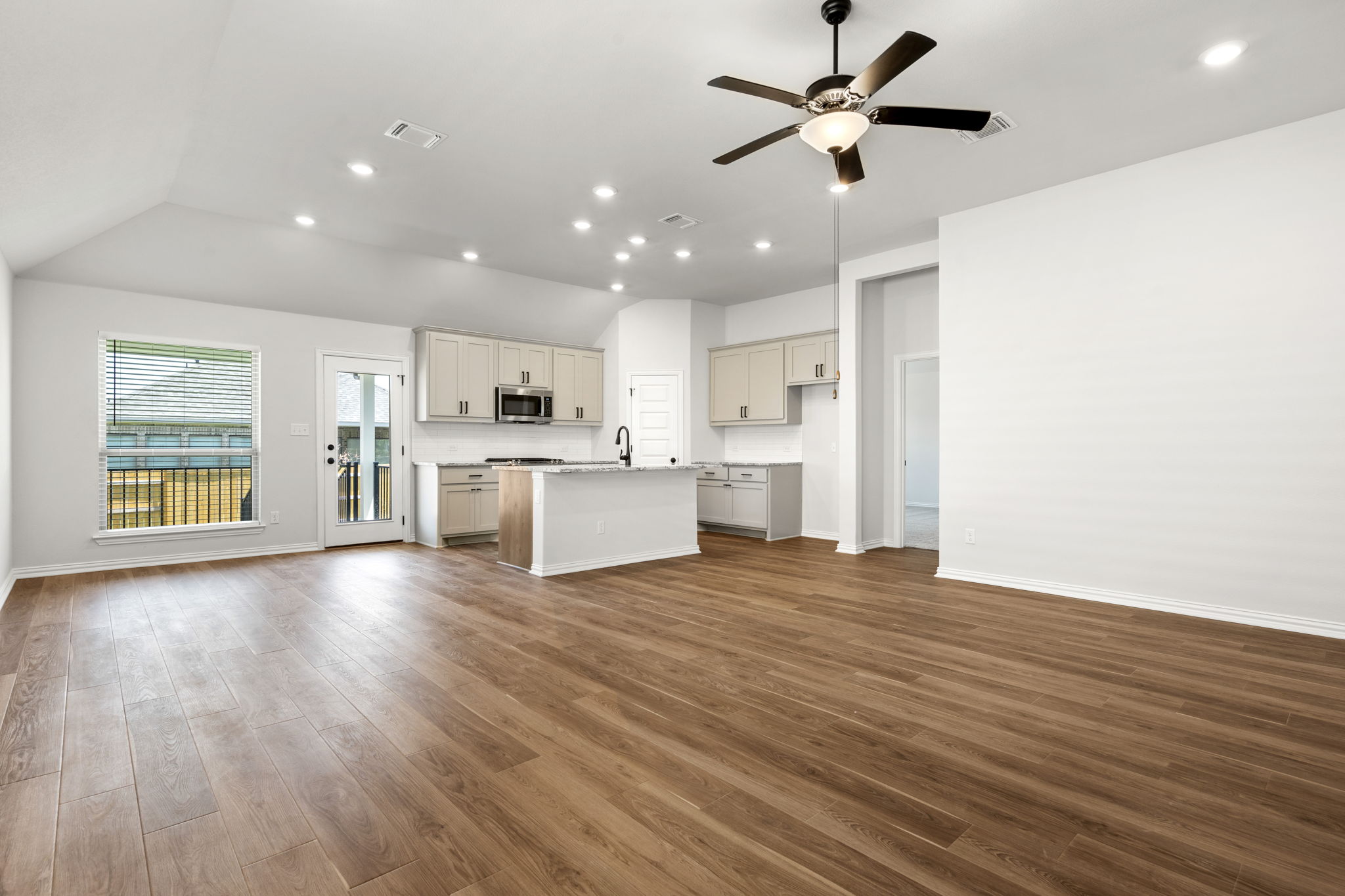 341 Fawn Riv Run Kyle, TX 78640 - Photo 28 of 29 Kitchen featuring visible vents, ceiling fan, stainless steel microwave, an island with sink, and open floor plan