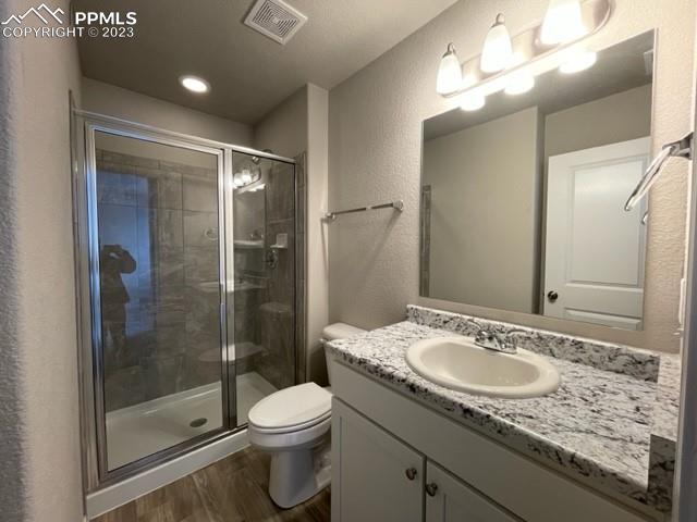 2931 Magic Carpet Loop Colorado Springs, CO 80916 - Photo 13 of 13 a bathroom with a granite countertop sink a toilet a mirror and shower