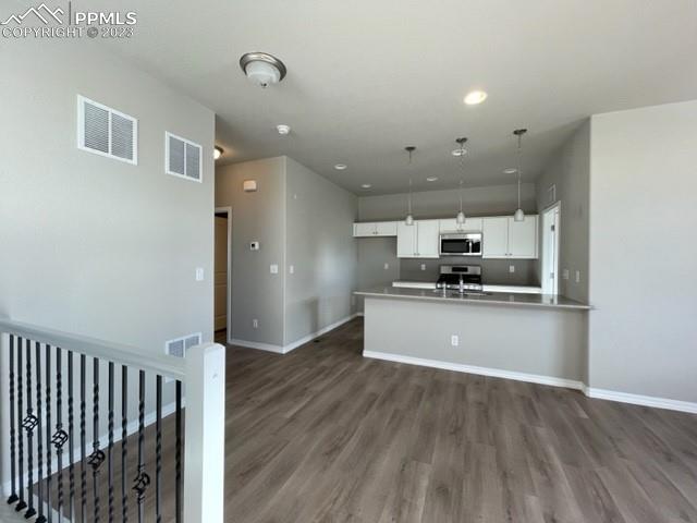 2931 Magic Carpet Loop Colorado Springs, CO 80916 - Photo 5 of 13 a large kitchen with stainless steel appliances kitchen island a refrigerator sink and cabinets