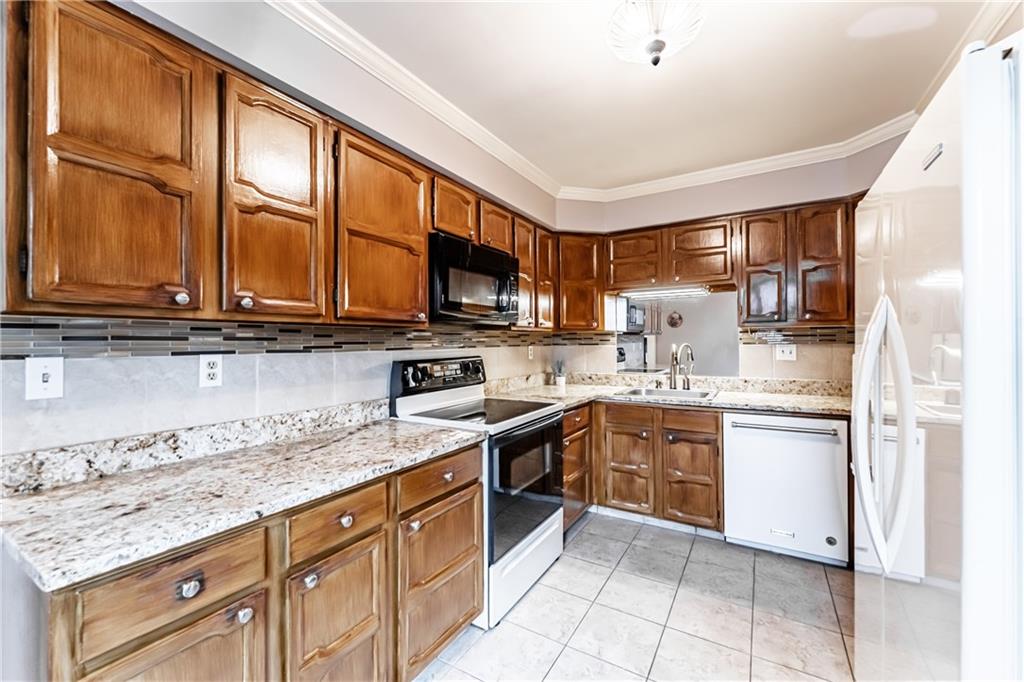 199 Roscommon Place Canonsburg, PA 15317 - Photo 7 of 32 a kitchen with stainless steel appliances granite countertop a stove top oven a sink dishwasher a dining table and chairs with wooden floor
