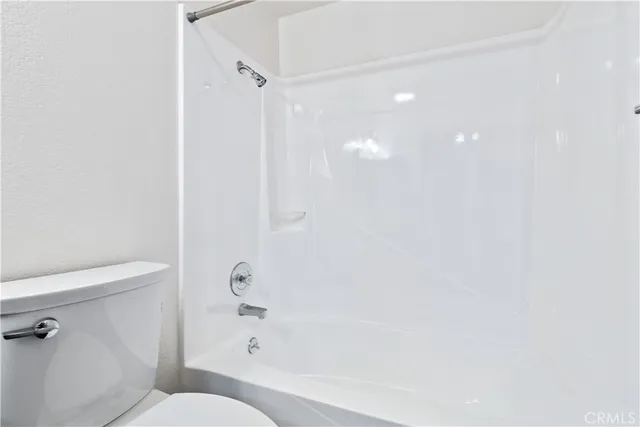 an empty room with wooden floor and ceiling fan