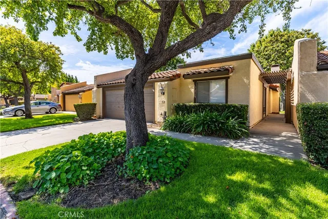 a front view of a house with a garden and trees