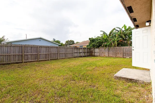 a white house that has tree in front of it