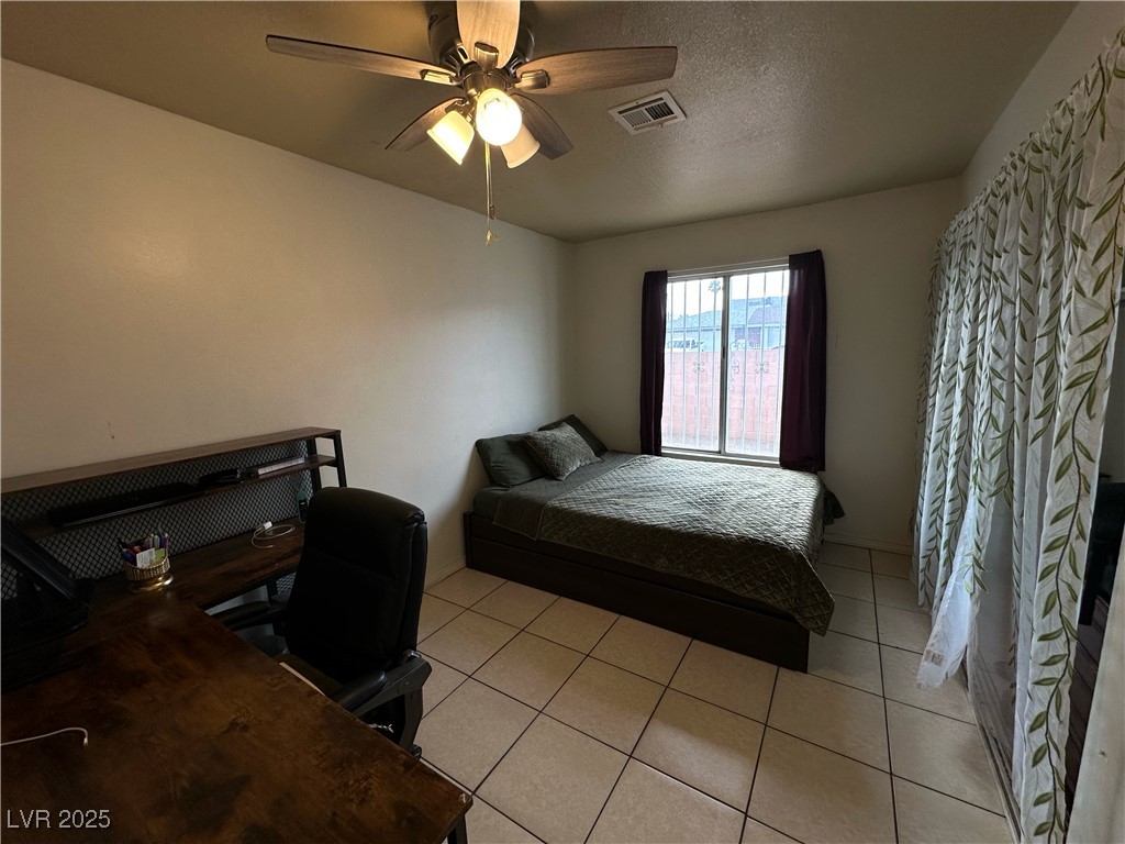3936 Rive Gauche Street Las Vegas, NV 89115 - Photo 22 of 30 Bedroom with ceiling fan, light tile patterned flooring, and an office area