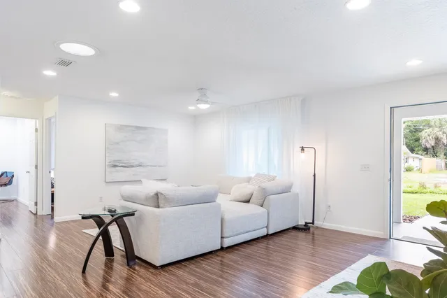 a living room with furniture and a wooden floor