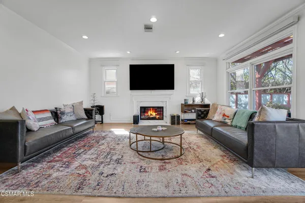 a living room with furniture a flat screen tv and a fireplace