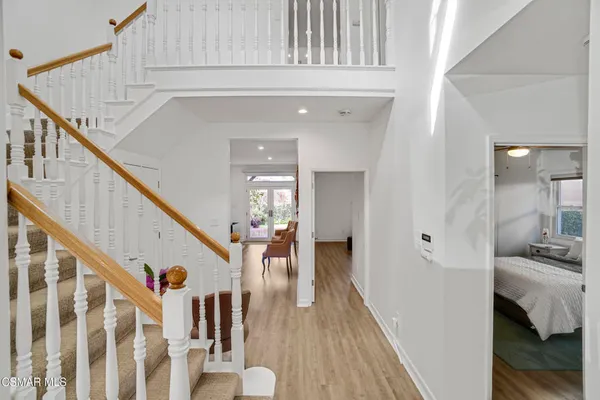 a view of a livingroom with wooden floor and stairs