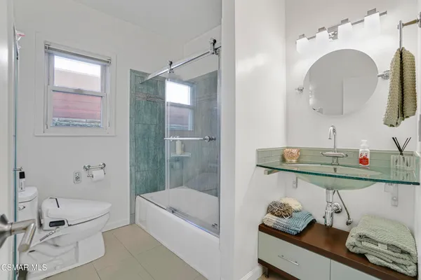 a bathroom with a tub sink and mirror