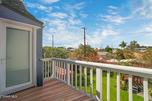 a view of a balcony with wooden floor and fence
