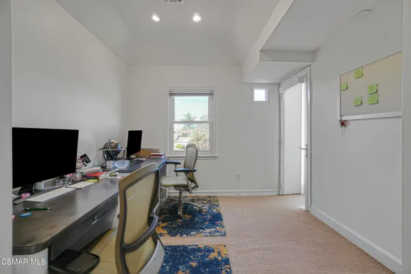 a view of a workspace with furniture and a window