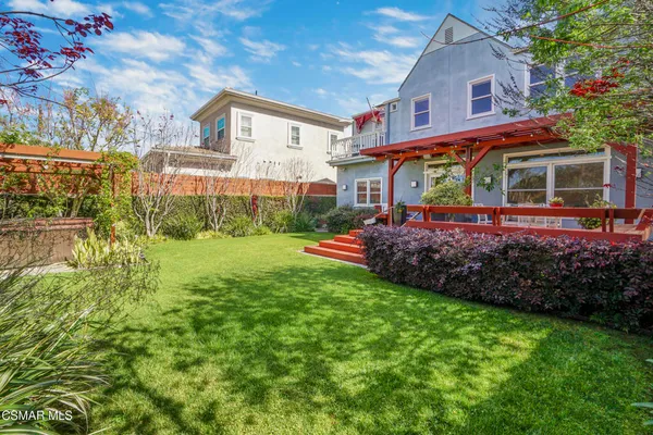 a front view of a house with a yard and potted plants