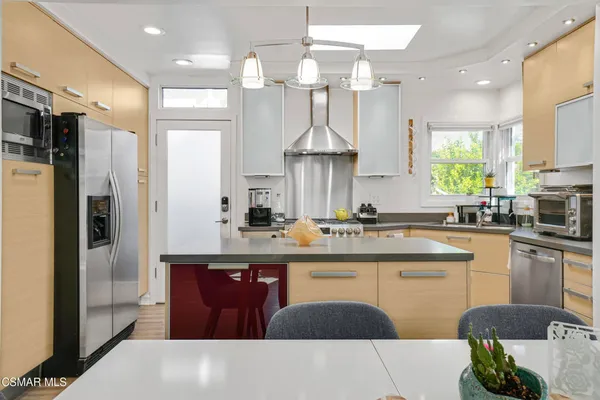 a kitchen with stainless steel appliances granite countertop a sink a stove and a refrigerator
