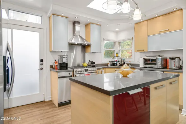 a kitchen with stainless steel appliances granite countertop a sink a stove a refrigerator and island