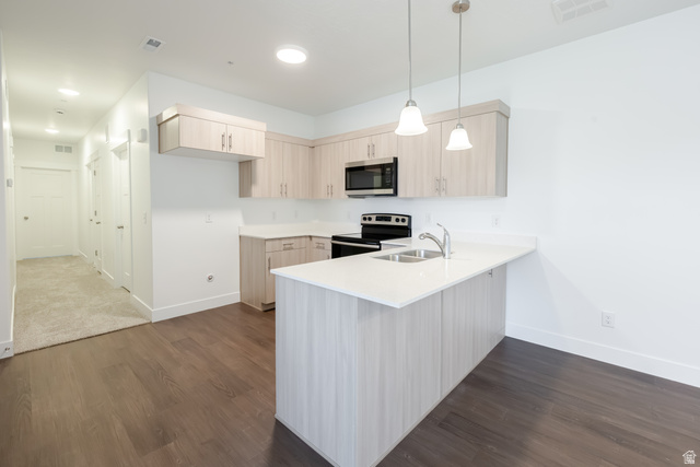 4727 South 690th West, Unit W201 Mapleton, UT 84664 - Photo 11 of 15 Modern kitchen featuring wood-finish cabinetry, stainless steel appliances, and a central island with a sink