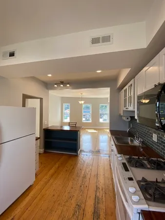 a view of a living room and kitchen with wooden floor