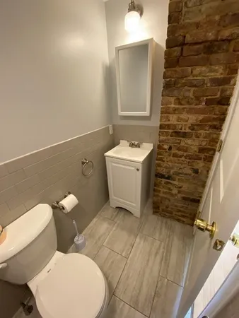 a bathroom with a toilet sink and mirror