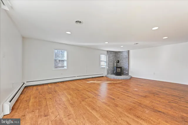 a view of empty room with wooden floor and window