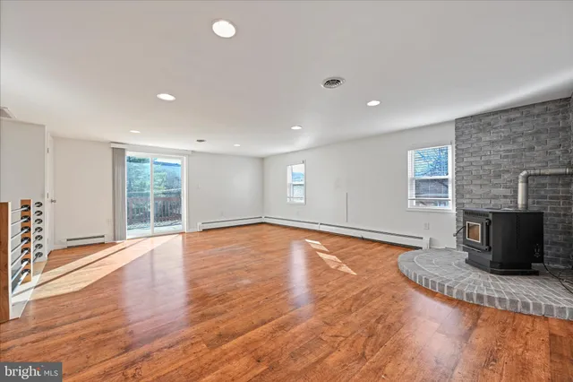 a view of a livingroom with wooden floor and a fireplace