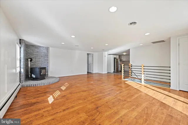 a view of an empty room with kitchen and a window