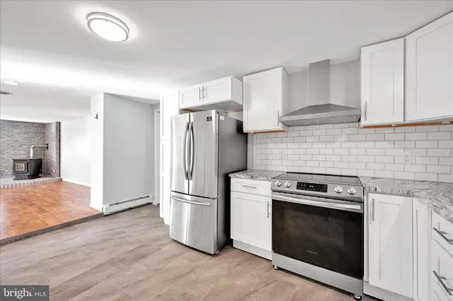 a kitchen with a stove top oven and refrigerator