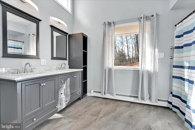 a spacious bathroom with a double vanity sink and a mirror