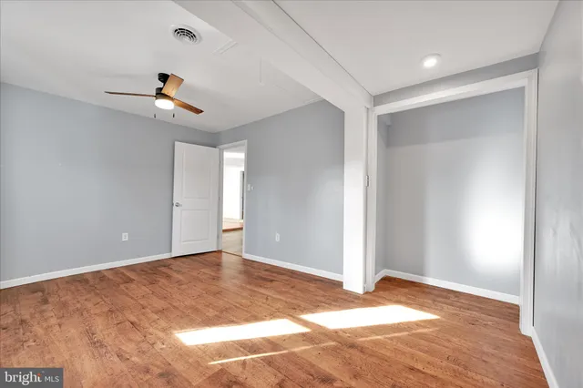 a view of a room with a ceiling fan and window