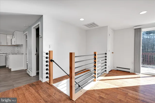 a view of a livingroom with wooden floor and staircase