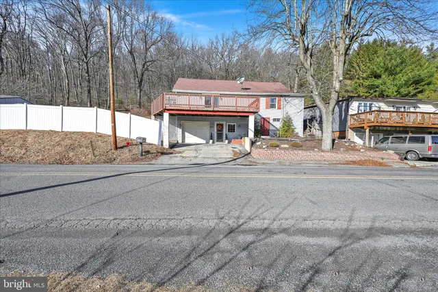 a house view with a sitting space and large trees