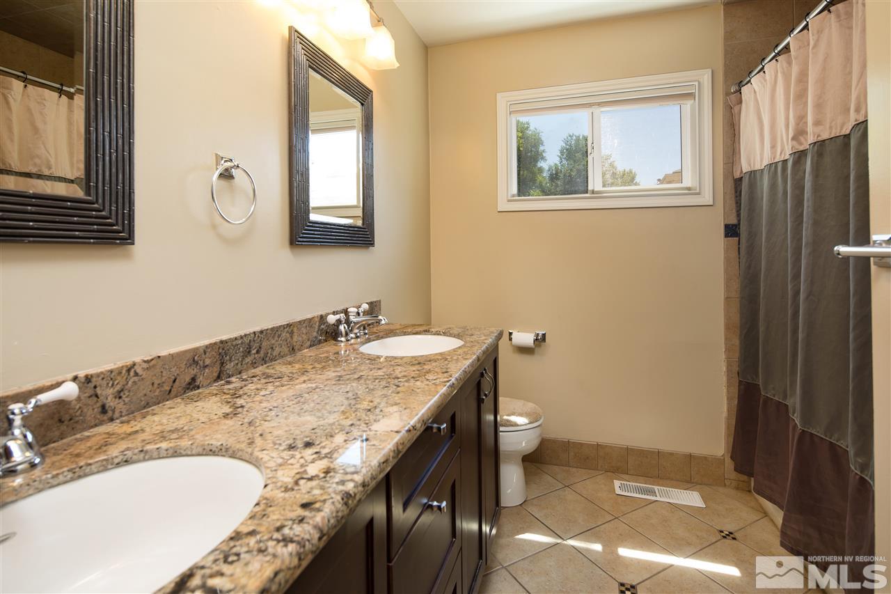 70 Bisby Street Reno, NV 89512 - Photo 13 of 25 a bathroom with a granite countertop sink and a mirror