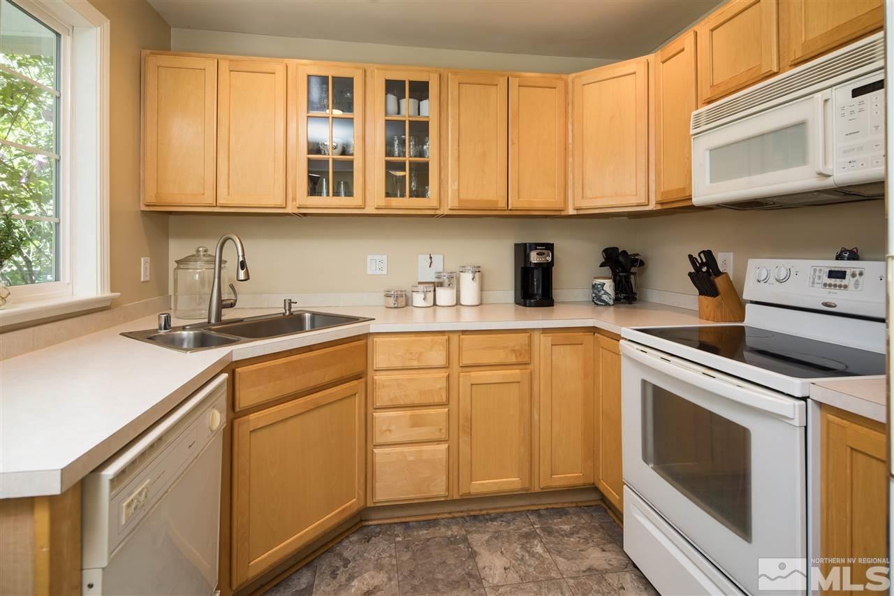 70 Bisby Street Reno, NV 89512 - Photo 7 of 25 a kitchen with stainless steel appliances granite countertop white cabinets sink and dishwasher
