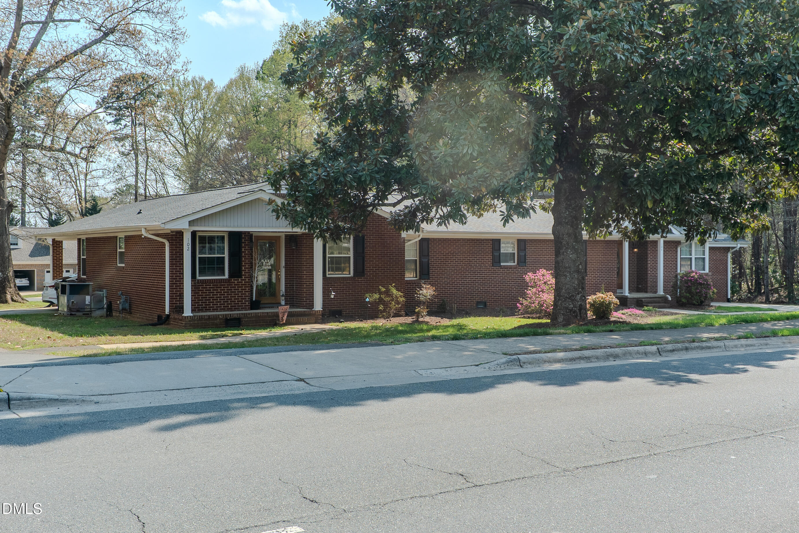 2012 South Mebane Street, Unit 102 Burlington, NC 27215 - Photo 22 of 35 a view of a white house in a big yard with large trees