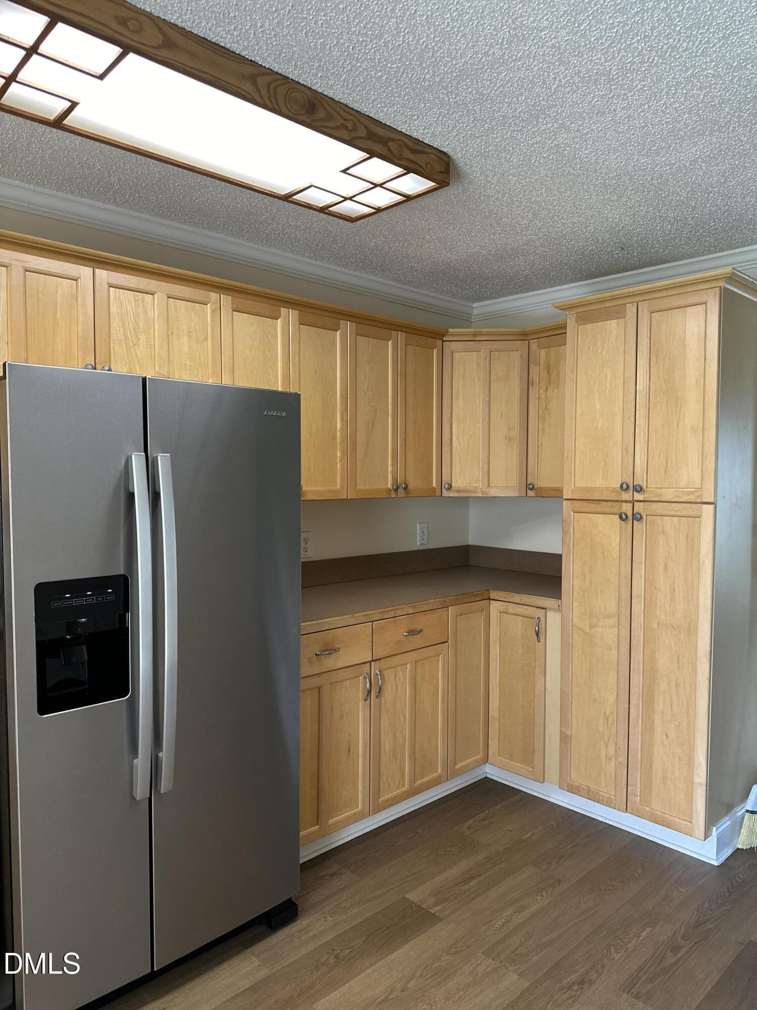 2012 South Mebane Street, Unit 102 Burlington, NC 27215 - Photo 29 of 35 a kitchen with granite countertop a refrigerator a sink and dishwasher with wooden floor