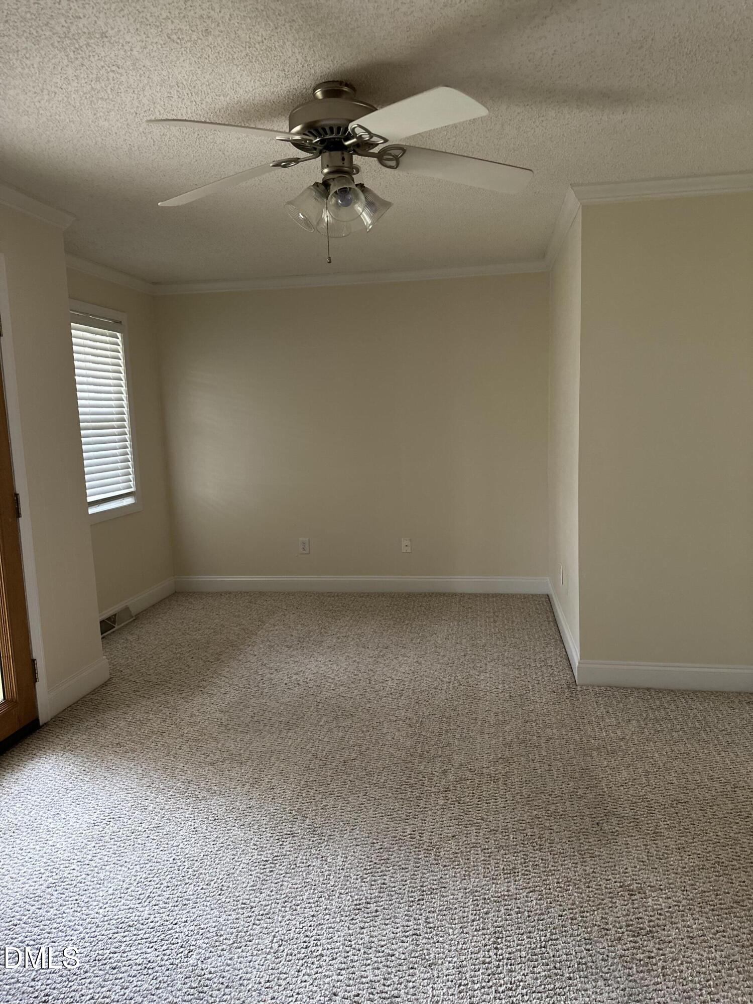 2012 South Mebane Street, Unit 102 Burlington, NC 27215 - Photo 30 of 35 an empty room with a chandelier fan and windows